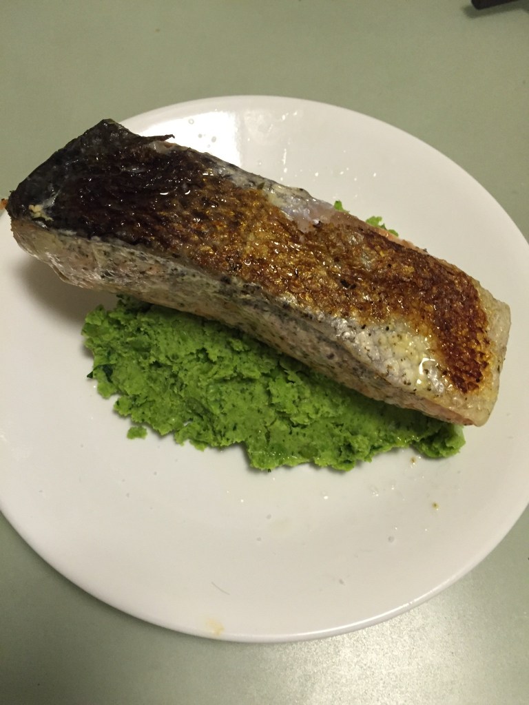 Crispy-skin salmon on peas