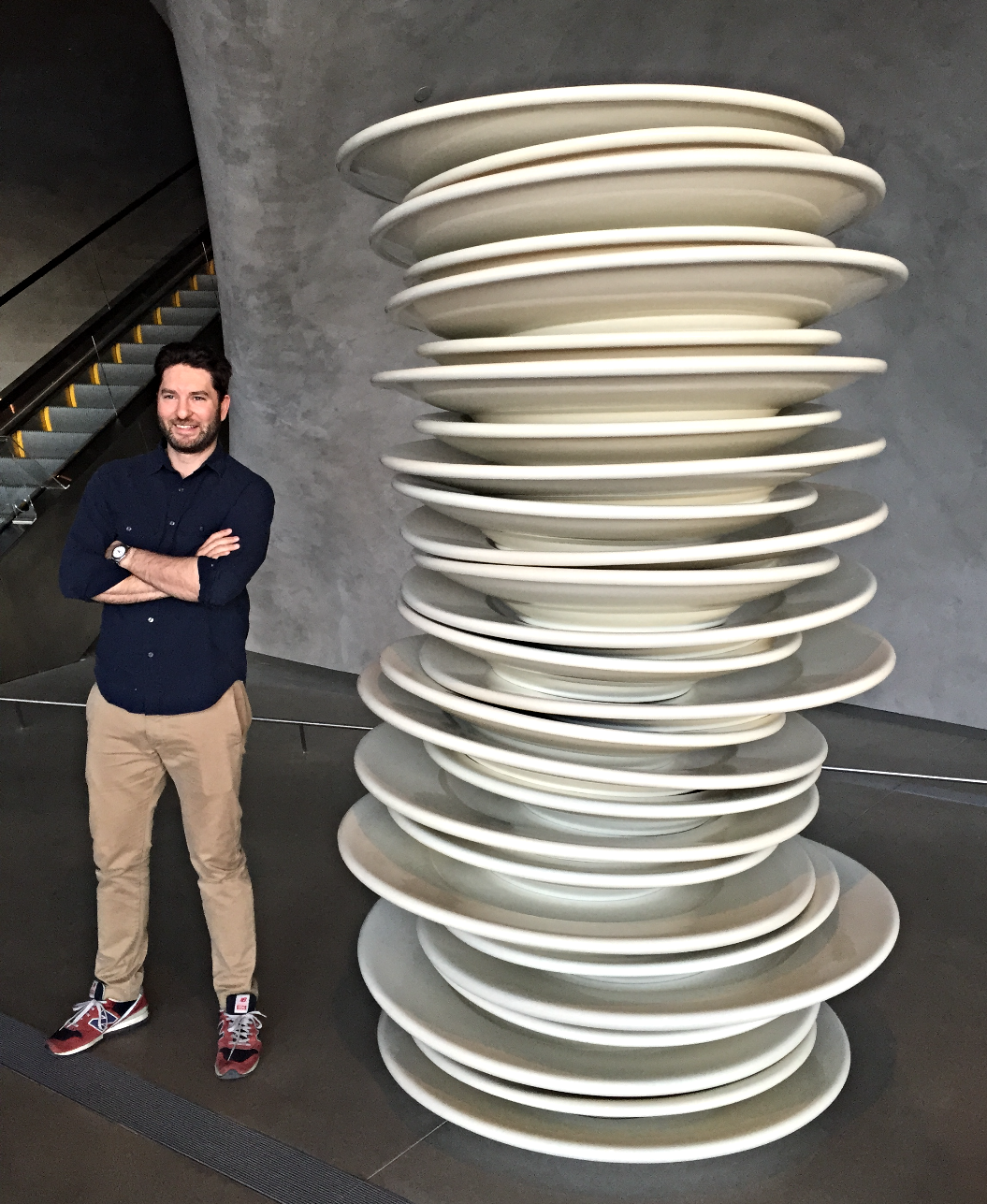 Alex standing beside a tower of stacked plates